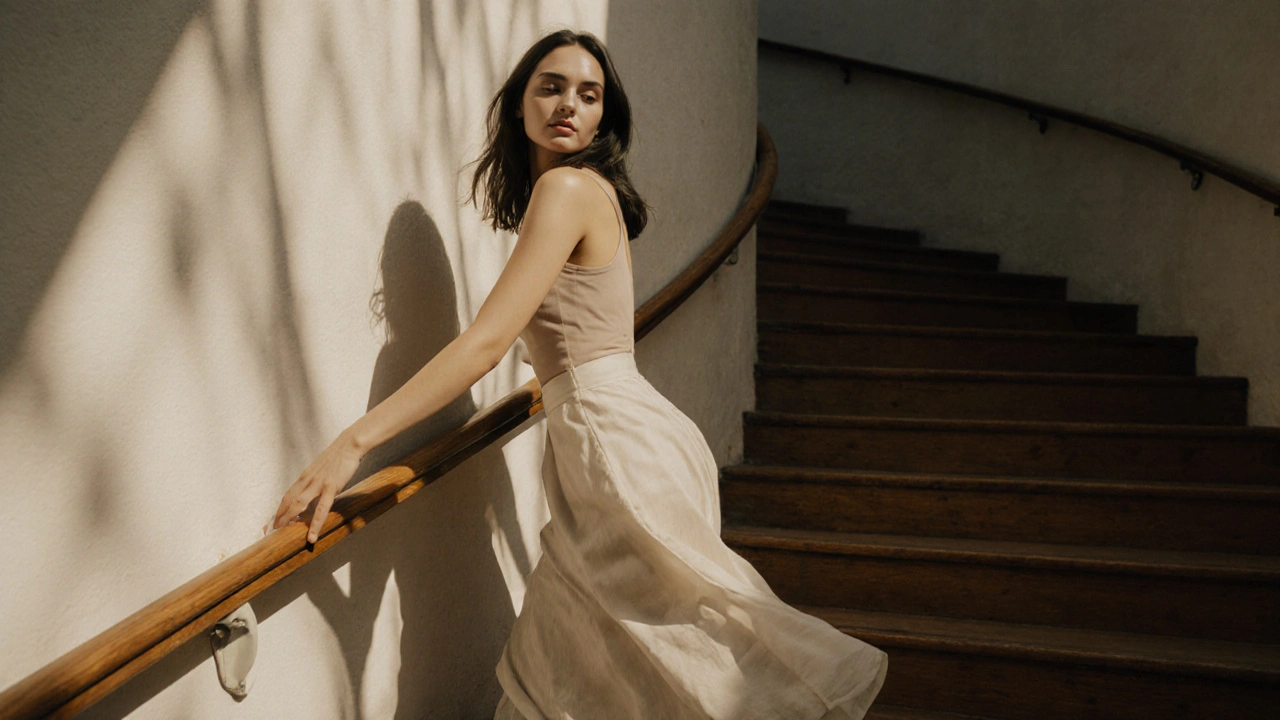 Model moving gracefully on a staircase, hand on railing, glancing over shoulder, soft sunlight.